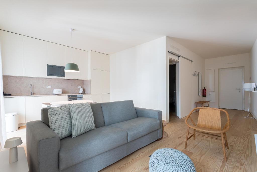 uma sala de estar com um sofá e uma cozinha em FLH Bairro Alto Modern Flats em Lisboa