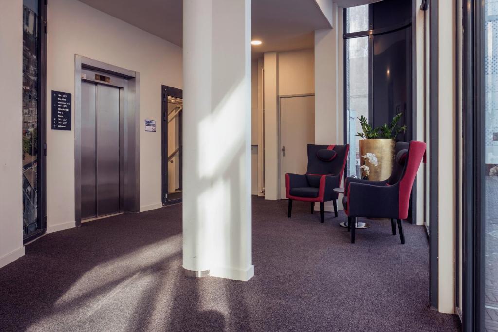 a hallway with chairs and a table in a building at Best Western Plus Plaza Den Haag City Center in The Hague