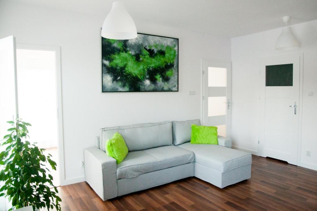 a living room with a couch and a painting on the wall at Apartament Verde in Łódź