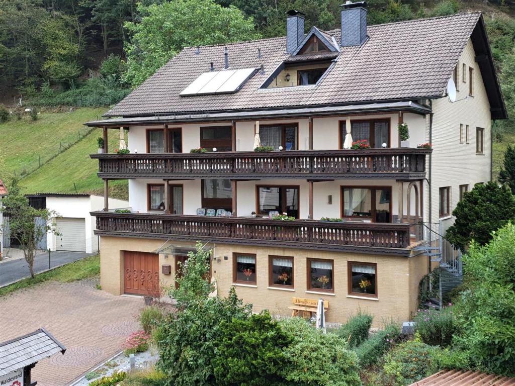a large house with a balcony on top of it at Haus Am Waldesrand in Herzberg am Harz