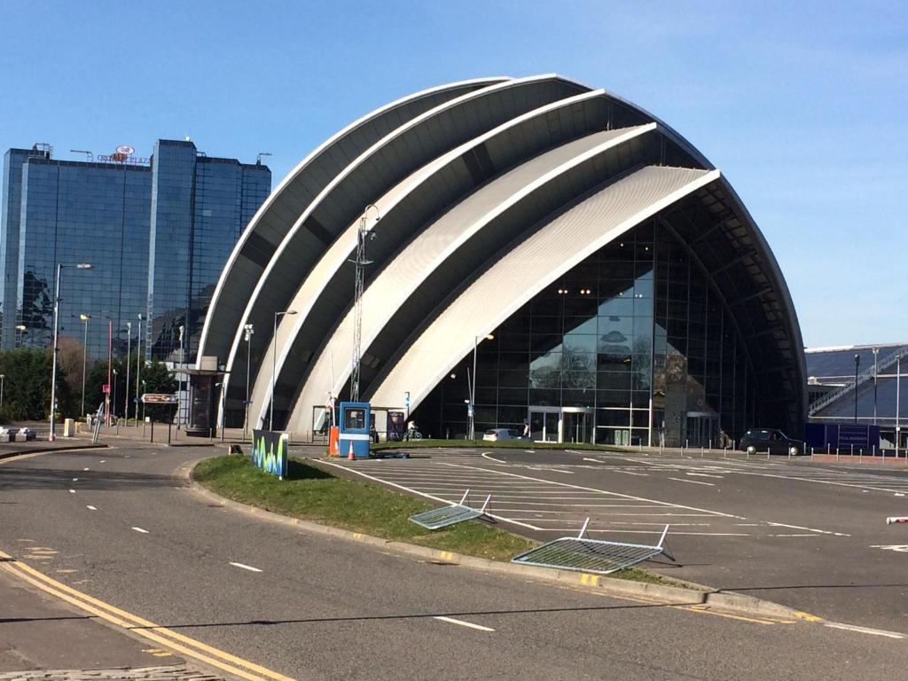 um grande edifício com um telhado curvado num parque de estacionamento em Riverheights very near SSE Hydro em Glasgow