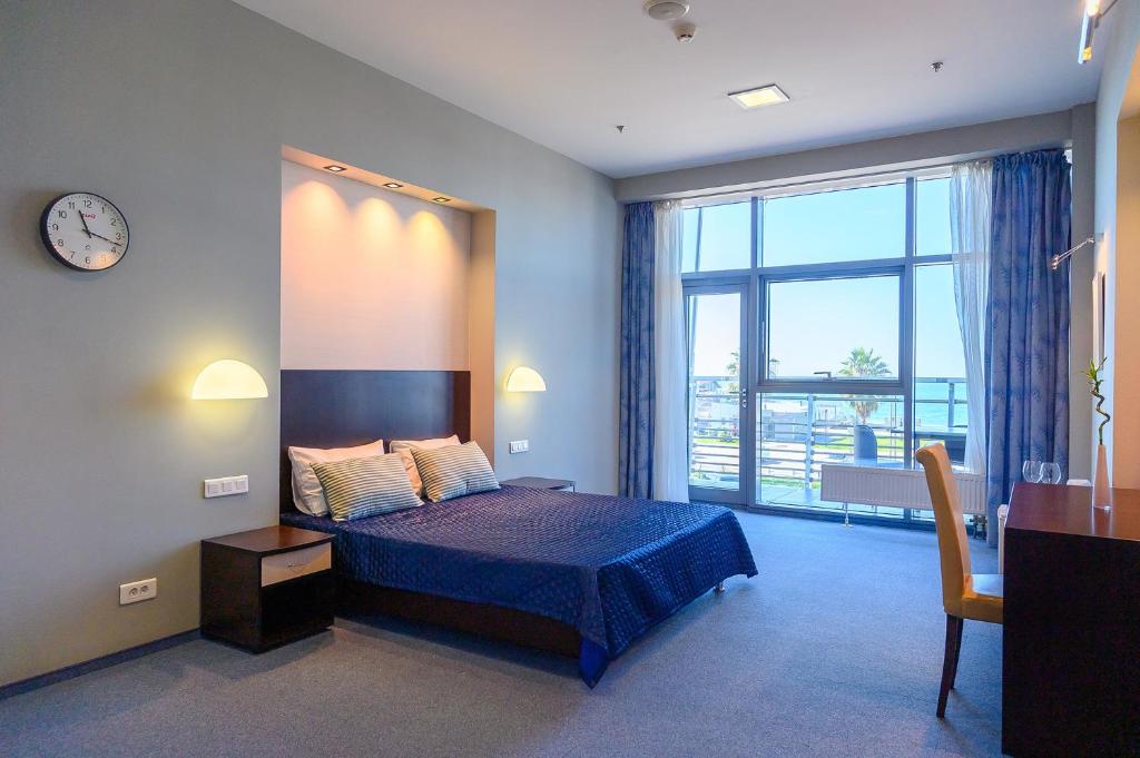 a bedroom with a bed and a clock on the wall at Hotel Terminal Adler in Adler