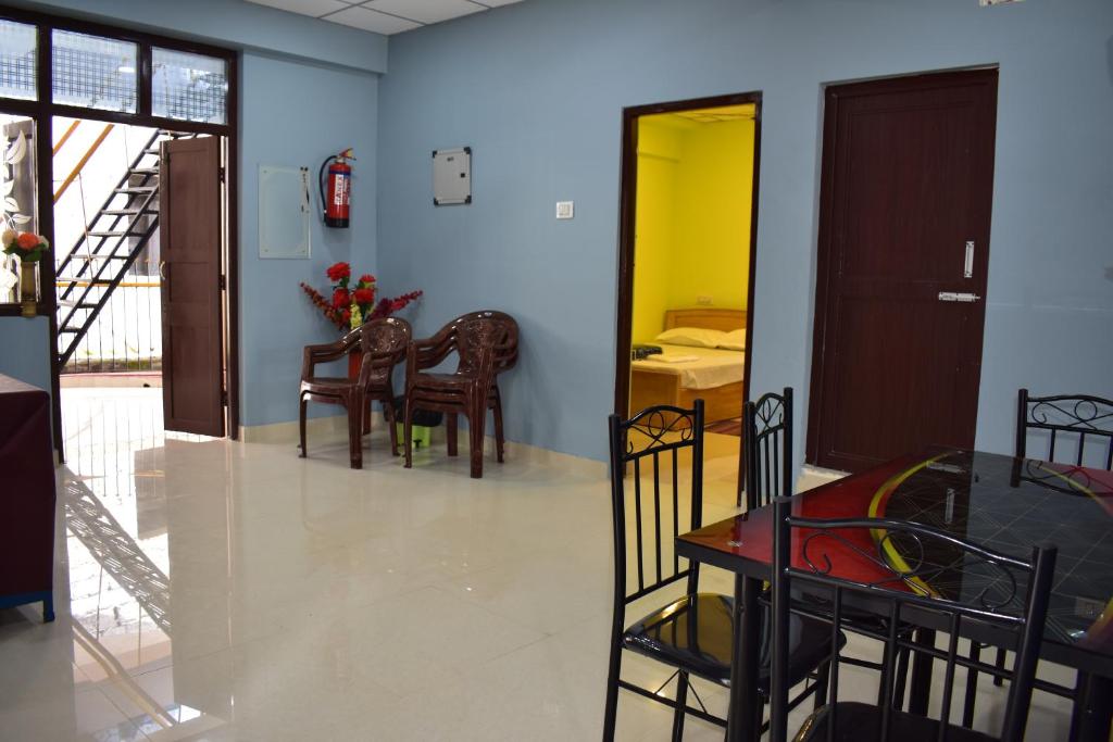 a room with a table and chairs and a dining room at Malakar Home stay in Port Blair