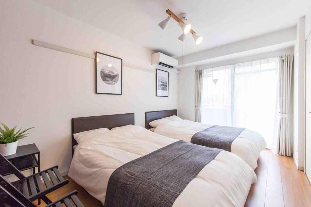 - une chambre avec 2 lits et une fenêtre dans l'établissement SHINJUKU Residence BLDG, à Tokyo