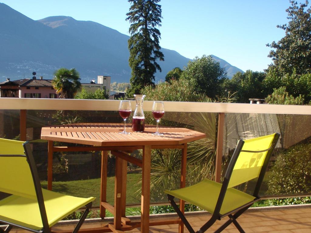 - une table avec deux verres de vin et deux chaises dans l'établissement Muralto-Locarno: Miramonti Apt. 8, à Muralto