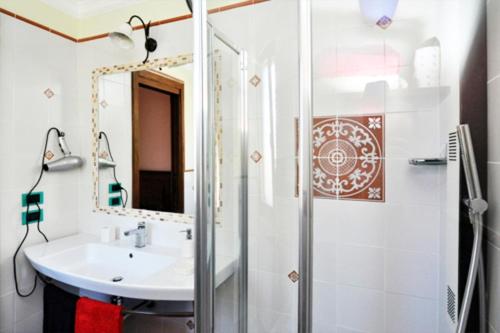 łazienka z umywalką i prysznicem z lustrem w obiekcie B&B IL PINO w mieście Pescocostanzo