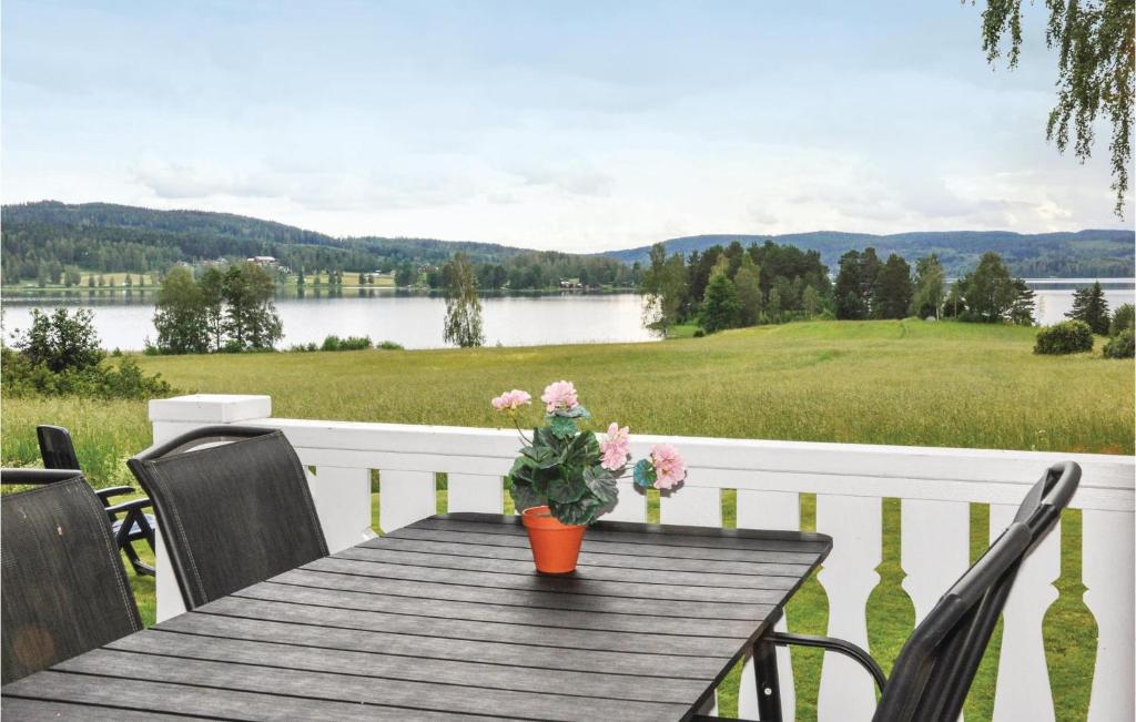 una mesa de madera con un jarrón de flores en un porche en 2 Bedroom Stunning Home In Gunnarskog en Gunnarskog