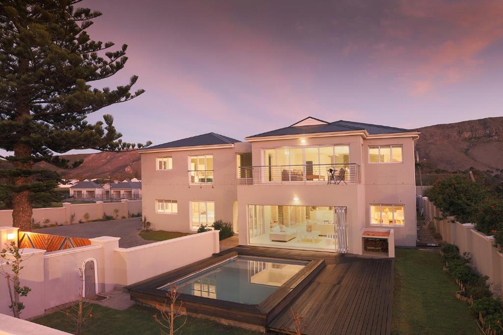 a large house with a swimming pool in the yard at 269 on Main Holiday Home in Hermanus