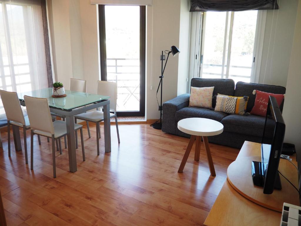 - un salon avec une table et un canapé dans l'établissement Apartamento Ainsa Pirineo, à Aínsa