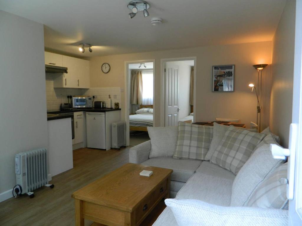 a living room with a couch and a table and a kitchen at Bespoke Chalet 214, walk to the beach & close to Norfolk broads - pet friendly! in Great Yarmouth