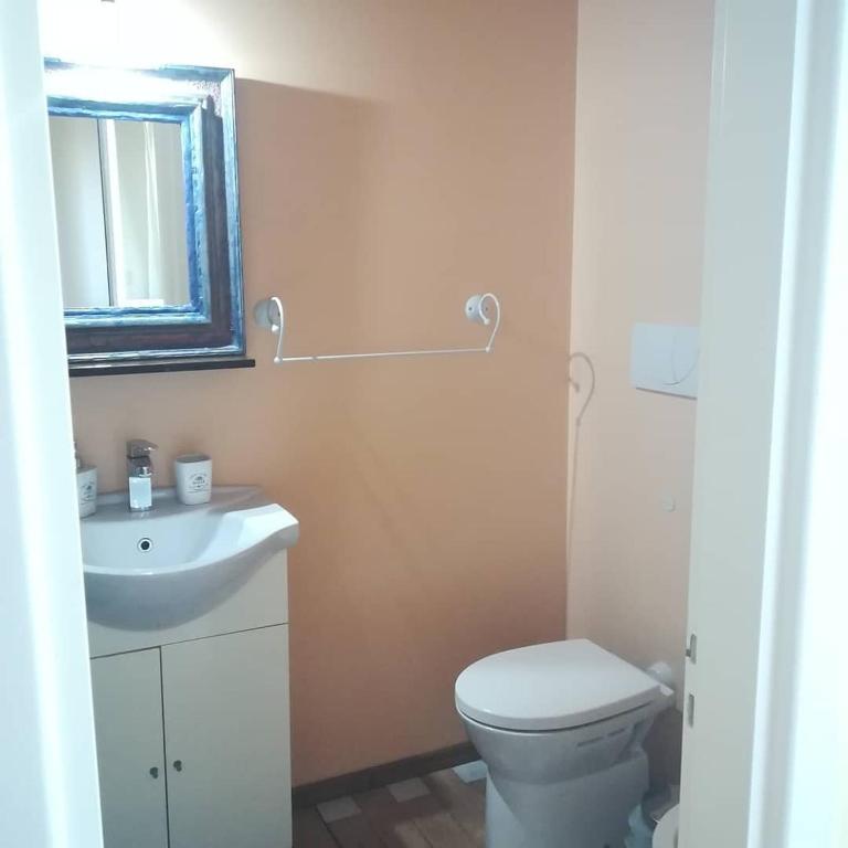 W łazience znajduje się toaleta, umywalka i lustro. w obiekcie Le Vallonee B&B w mieście Aradeo