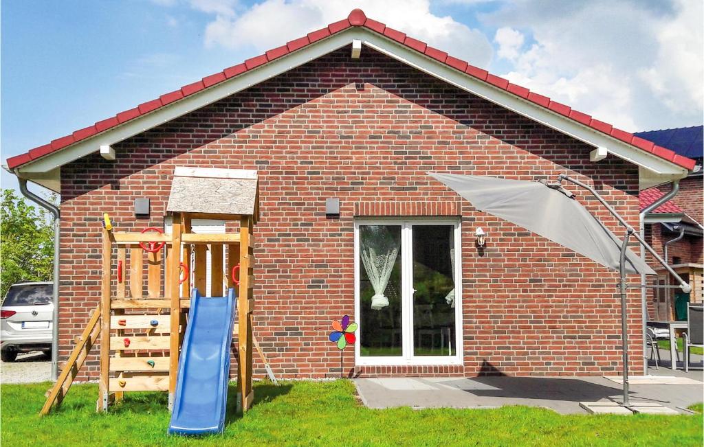 a brick house with a slide and an umbrella at Stunning Home In Boiensdorf With Sauna in Boiensdorf