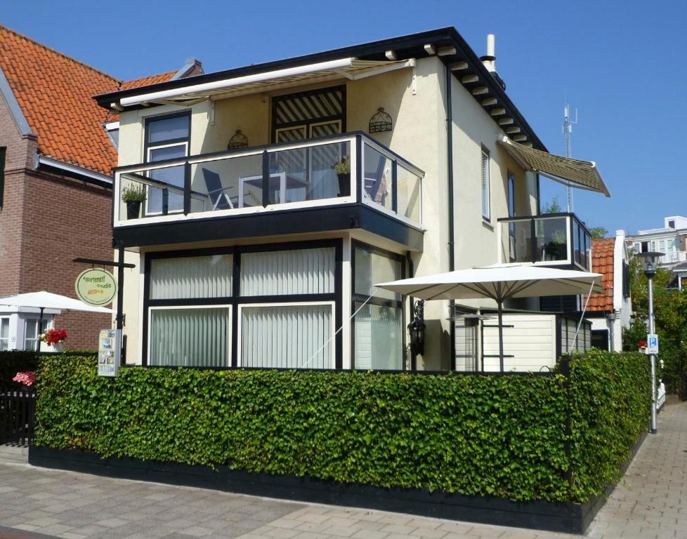 a large house with a balcony and an umbrella at Mevira Appartement in Zandvoort
