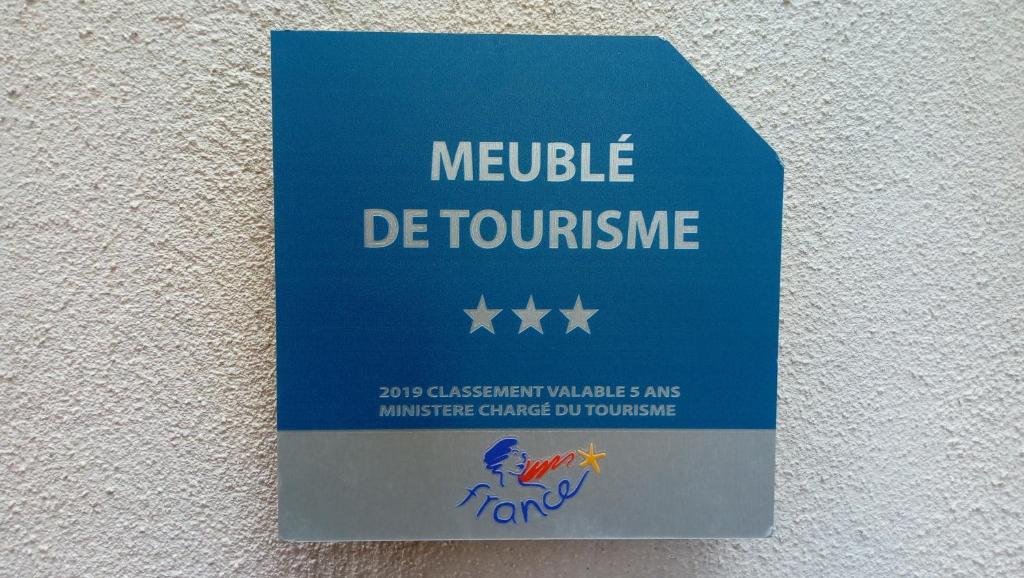 a blue sign on a wall that reads middle de tourism at Maison au pied de la cathédrale in Elne