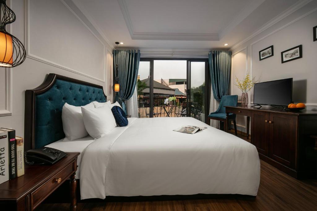 a bedroom with a large white bed and a window at Maya Boutique Hotel & Spa in Hanoi