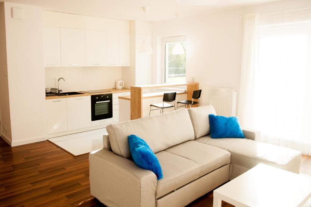 sala de estar con sofá y cocina en Apartament Blu, en Łódź