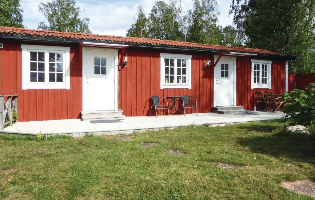 Cabaña roja con puertas blancas y sillas en un patio en Lovely Home In Trosa With Wifi en Trosa