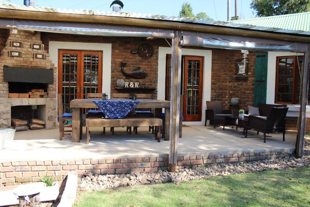 a patio with a table and a fireplace at Mickey Finn in Dullstroom