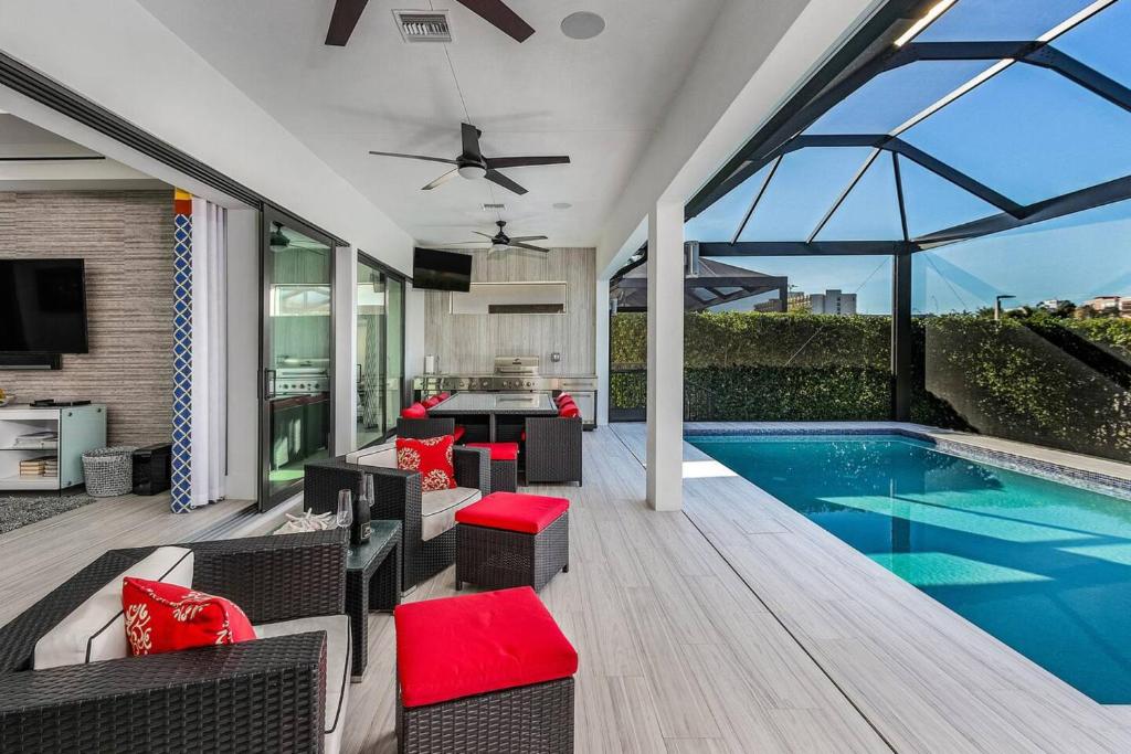 a living room with a swimming pool and a house at BEACH 5 MIN. WALK-LUXURIOUS MODERN POOL HOME in Marco Island