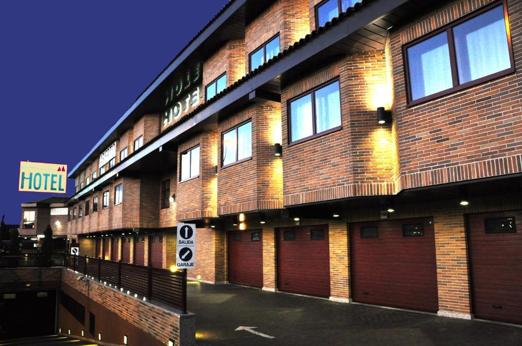 a tall brick building with doors and a sign on it at Hotel Los Peñascales - Adults Only in Las Rozas de Madrid