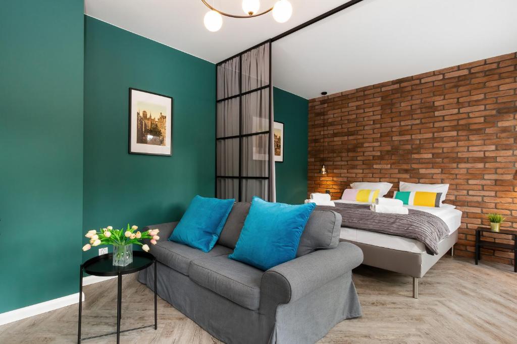 a living room with a couch and a bed at Apartments Gdańsk Rajska by Renters in Gdańsk