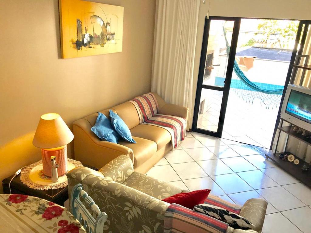 Sala de estar con 2 sofás y TV en Meia Praia 150 metros mar, en Itapema