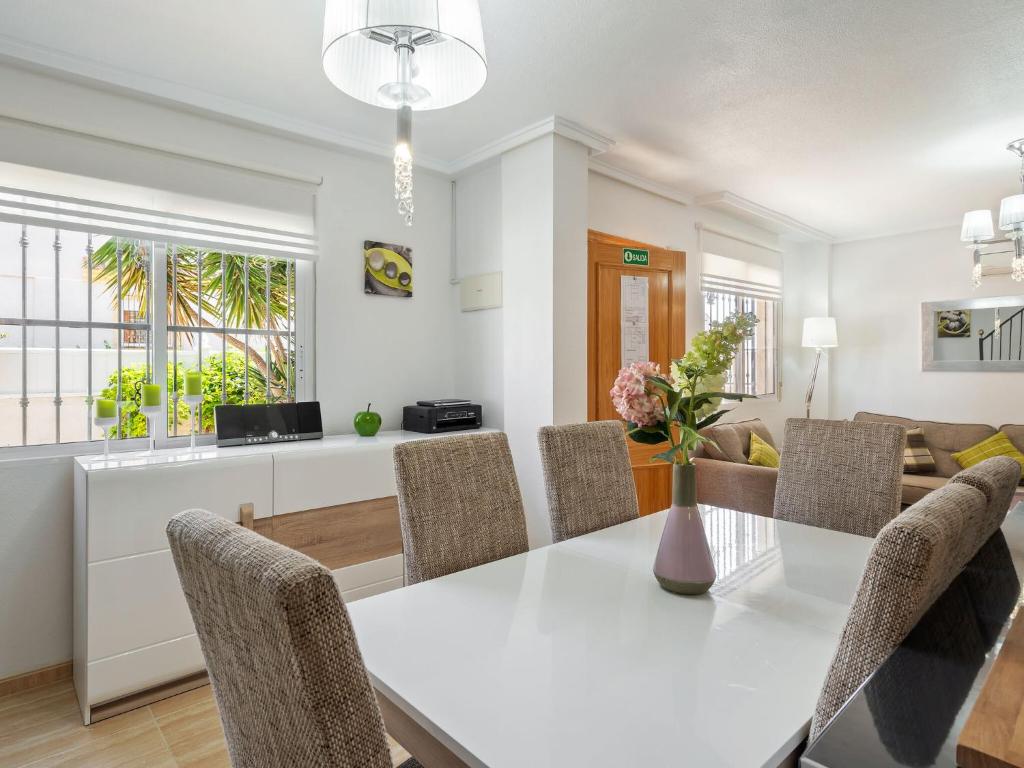 a dining room and living room with a white table and chairs at Belvilla by OYO Casa Crispin in Ciudad Quesada