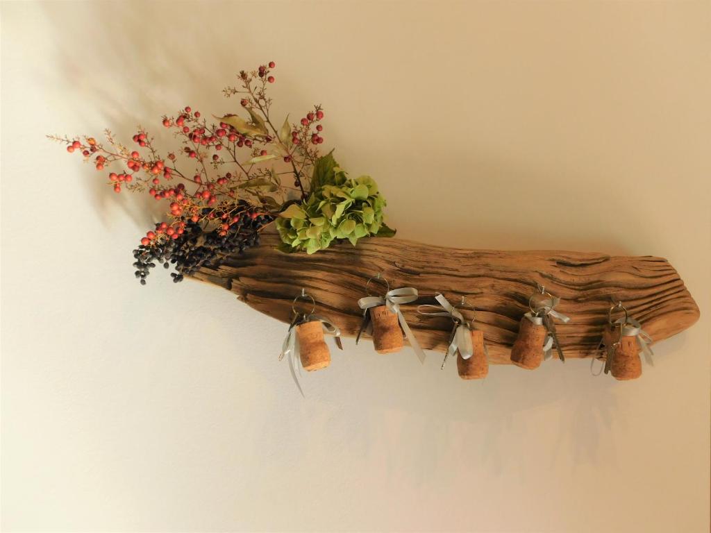 a wooden branch hanging on a wall with flowers at B&B Le Stanze di Amelie in Povegliano Veronese