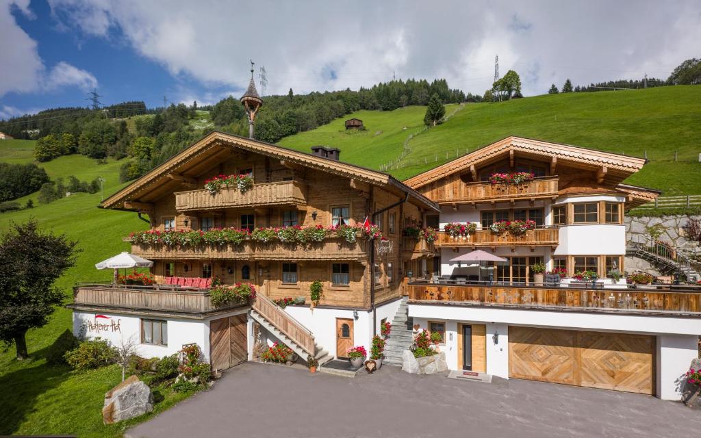 a large building with a green hill in the background at Hottererhof in Gerlos