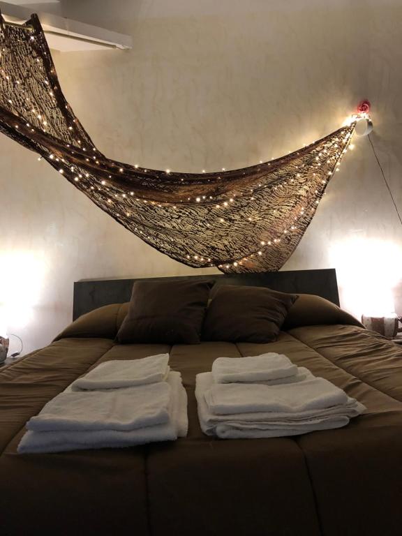 a bed with two white towels on it with a net at B&B Planet in Montalbano Ionico