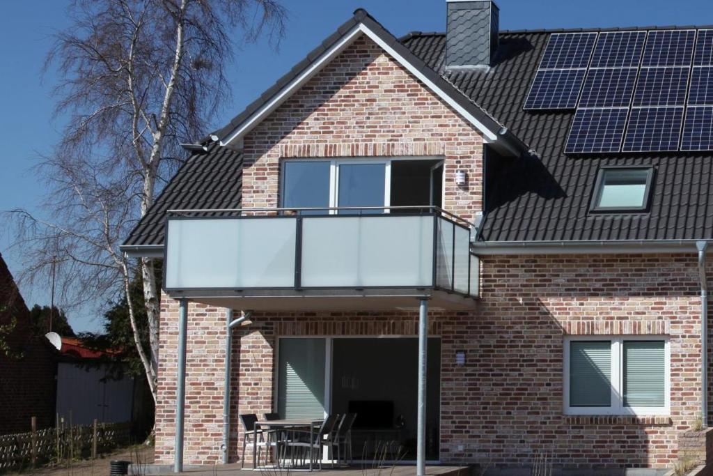 ein Haus mit einem Balkon mit Sonnenkollektoren auf dem Dach in der Unterkunft Ferienwohnung Seestern in Fehmarn