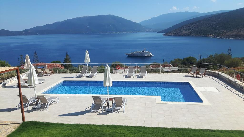 a swimming pool with a view of a lake and a boat at Verde e Mare in Agia Effimia