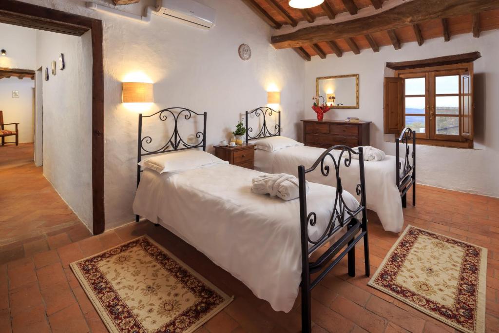 a bedroom with two beds in a room at Borgo Cortinova Marrocco in Rapolano Terme