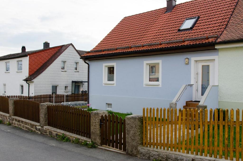 um grupo de casas brancas com uma cerca de madeira em Ferien - Knierer em Bärnau