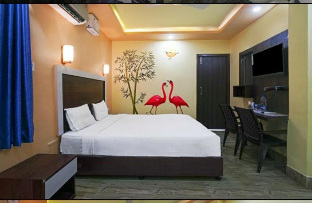 a bedroom with a bed with two flamingos on it at Ratna Resort in Khandagiri
