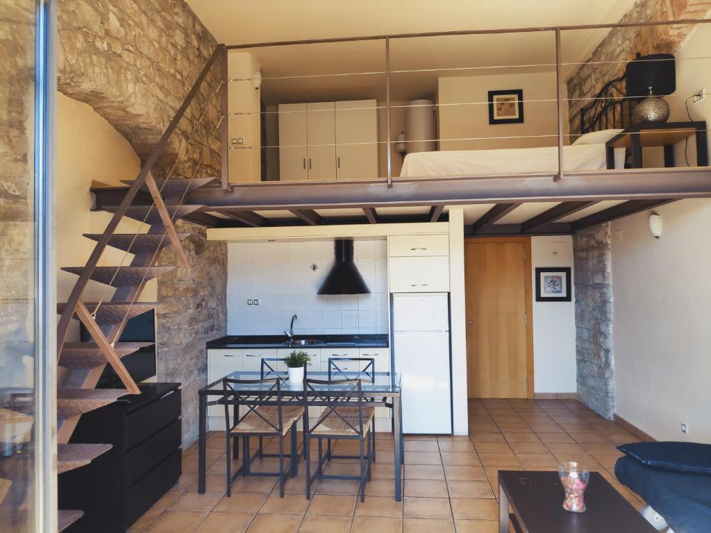 a loft apartment with a dining room and a loft bed at Urbi Apartments in Manresa