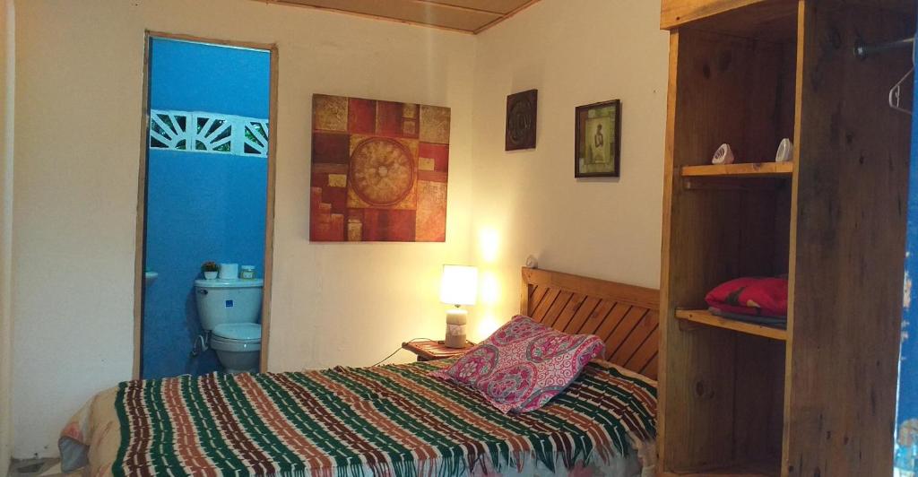 1 dormitorio con 1 cama, aseo y lámpara en La Casita de Don Daniel, en El Valle de Antón
