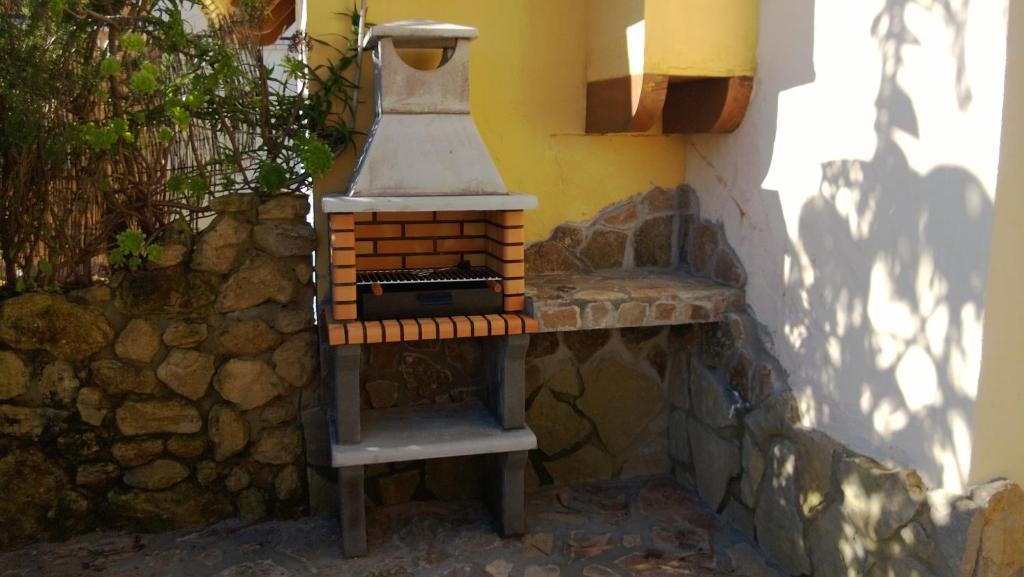 a brick oven sitting next to a stone wall at Casas El Suspiro in Zahora