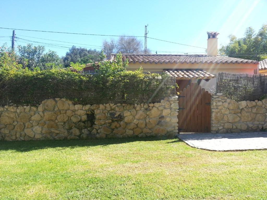 a stone fence next to a house with a gate at Casas El Suspiro in Zahora