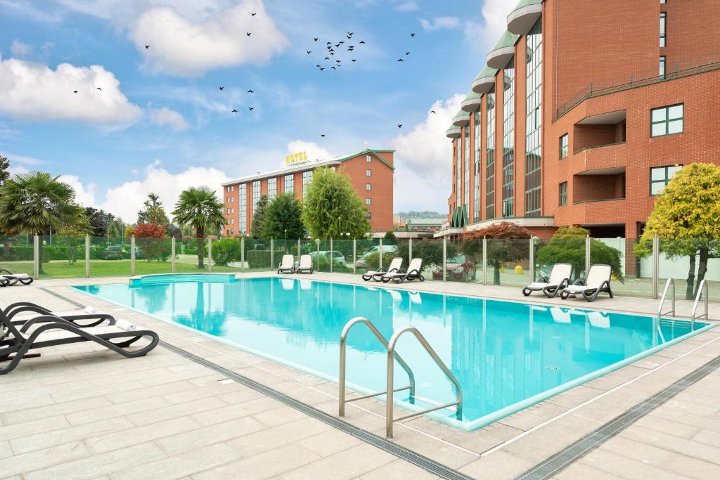 una grande piscina di fronte a un edificio di Rivoli Hotel a Rivoli