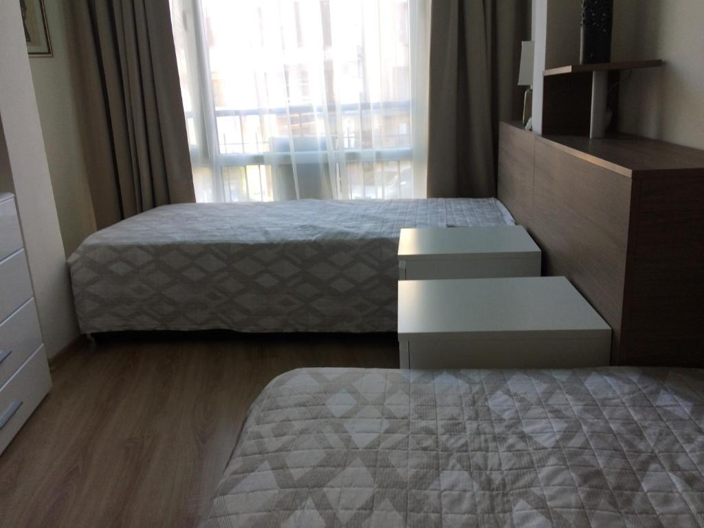 1 dormitorio con 1 cama, vestidor y ventana en Апартамент Мони, en Burgas