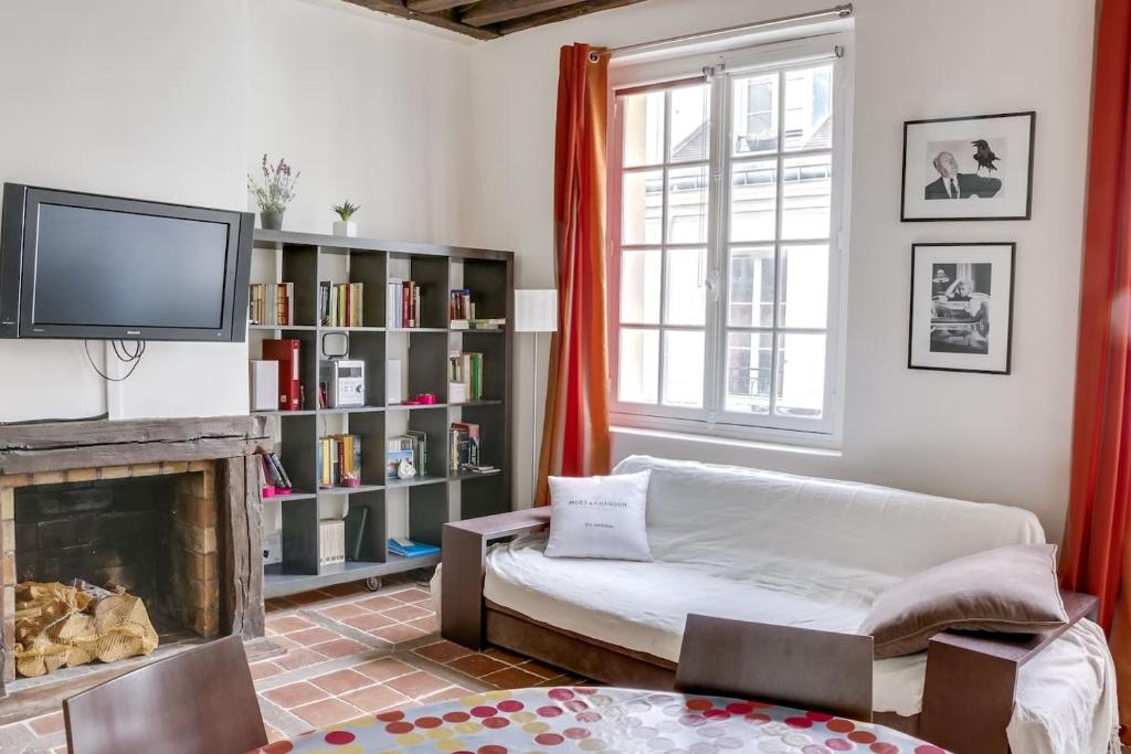 un salon avec un canapé et une cheminée dans l'établissement Unit 007 Marais Pompidou (michel le comte), à Paris