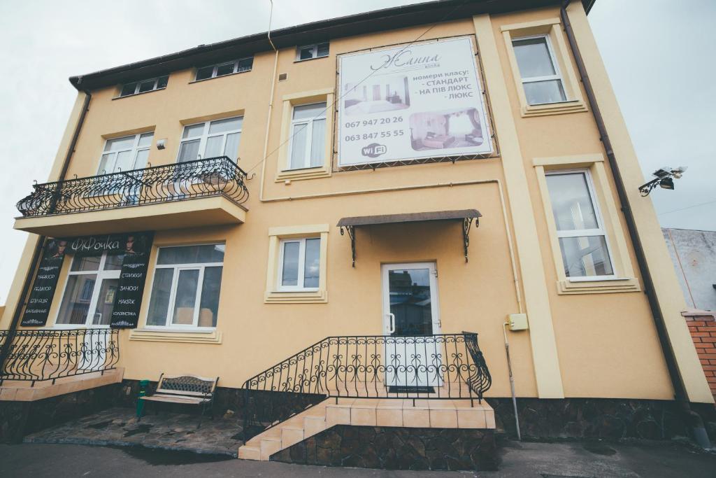 un edificio amarillo con un cartel en el costado en Villa Zhanna en Truskavets