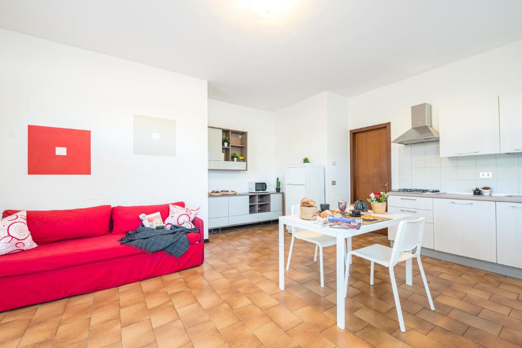 西爾米奧奈的住宿－Gardappartamenti Campiello Pool，客厅配有红色的沙发和桌子