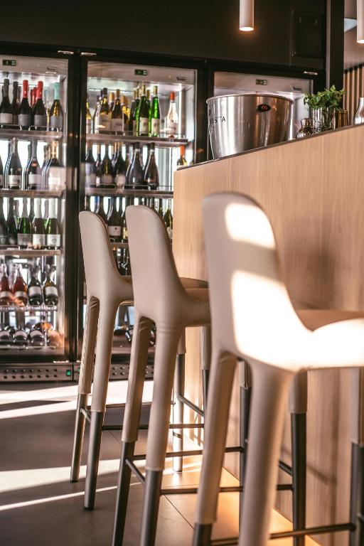 a row of white chairs in front of a bar at Mosella Suite Hotel in Sottomarina
