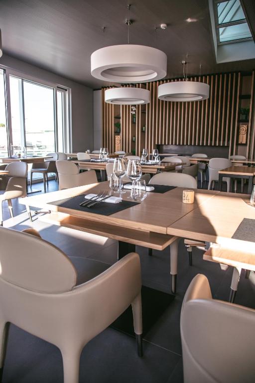 a restaurant with a large wooden table and chairs at Mosella Suite Hotel in Sottomarina