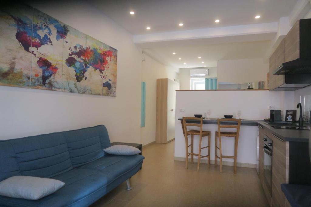 een woonkamer met een blauwe bank en een keuken bij Namastè monolocale in Ancona
