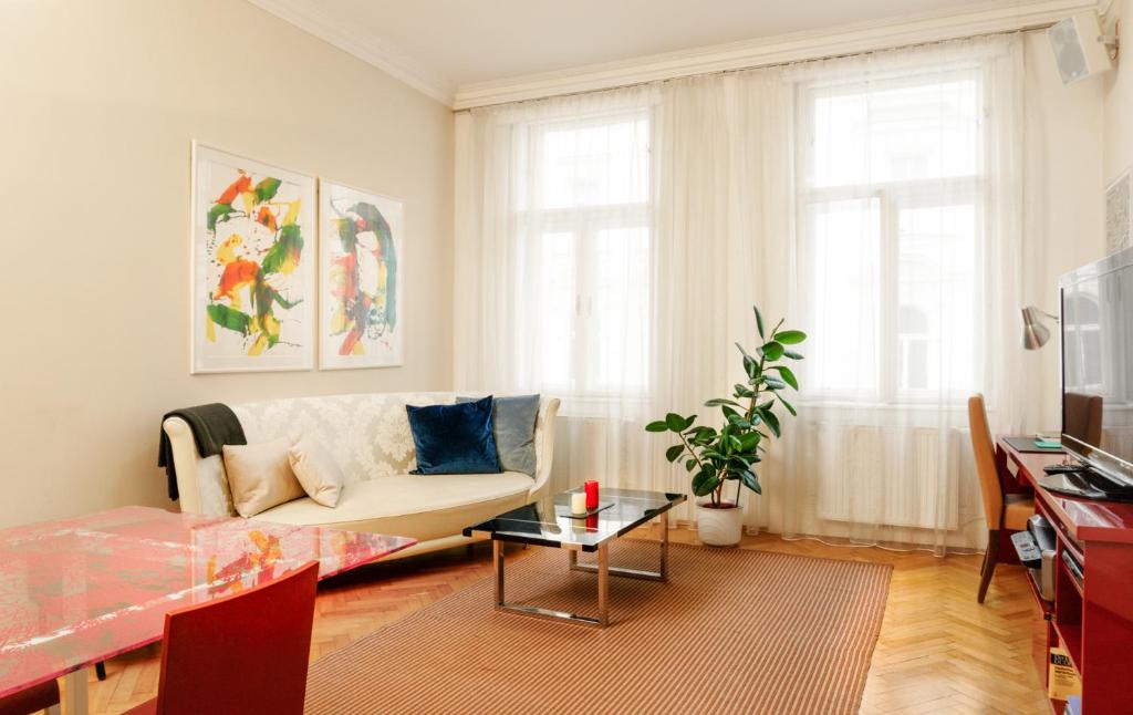 uma sala de estar com um sofá e uma mesa em Apartments Fuchsthallergasse em Viena