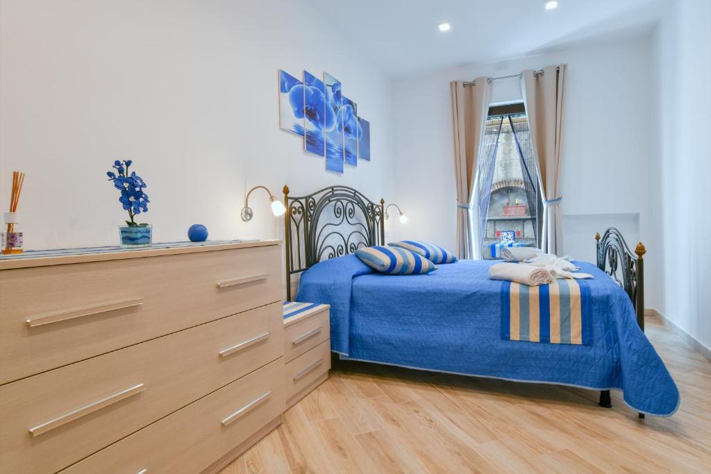 a bedroom with a blue bed and a dresser at Il Profumo di Capri in Massa Lubrense