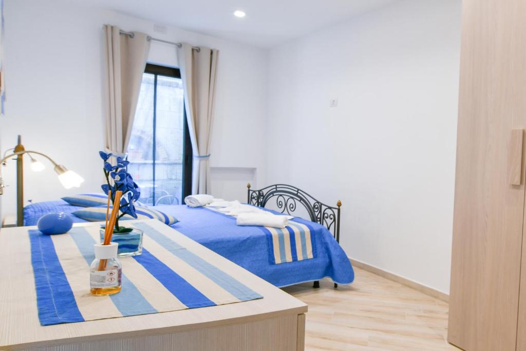 a bedroom with two beds with blue sheets and a table at Il Profumo di Capri in Massa Lubrense